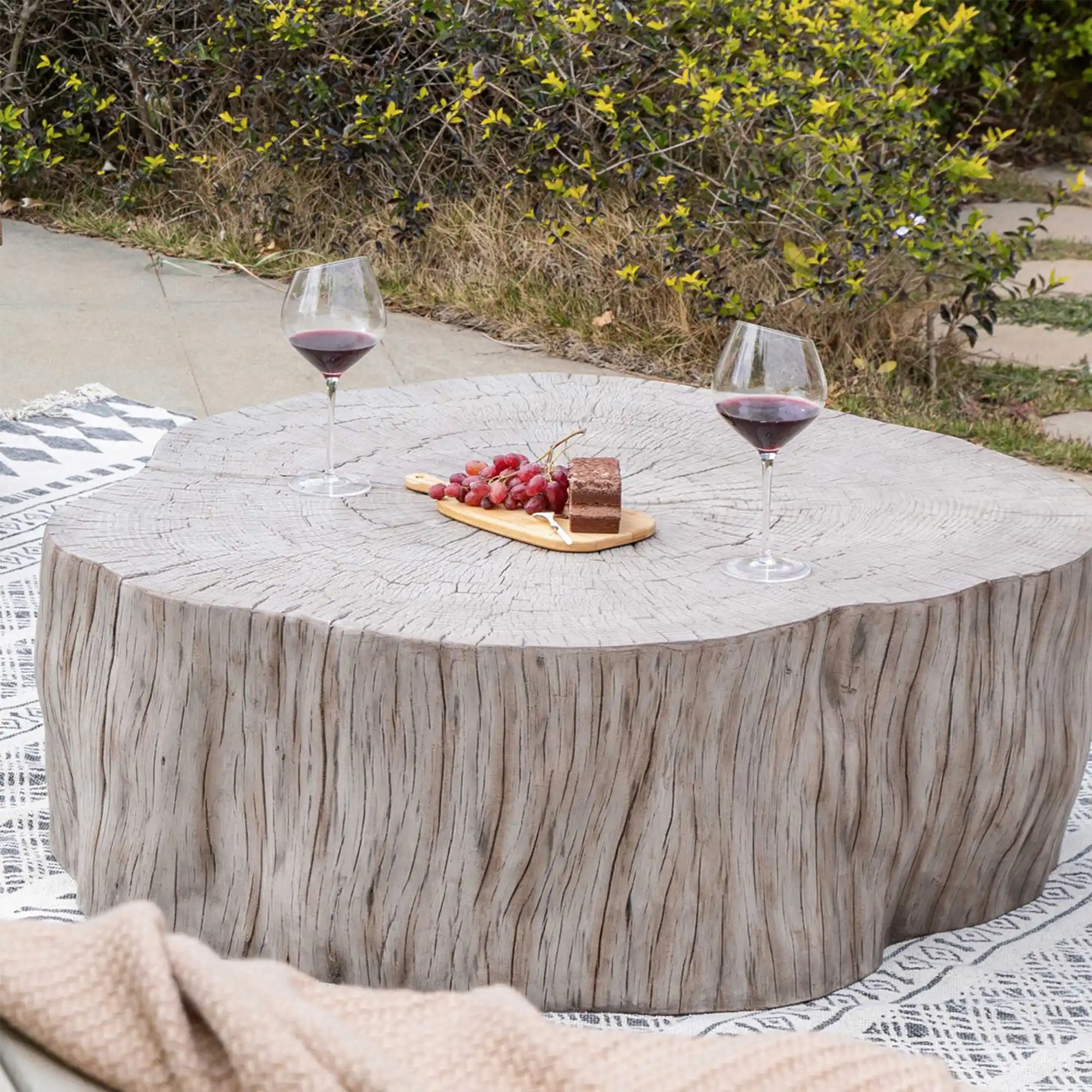 Table basse en b&eacute;ton en forme de tronc install&eacute;e dehors sur une terrasse