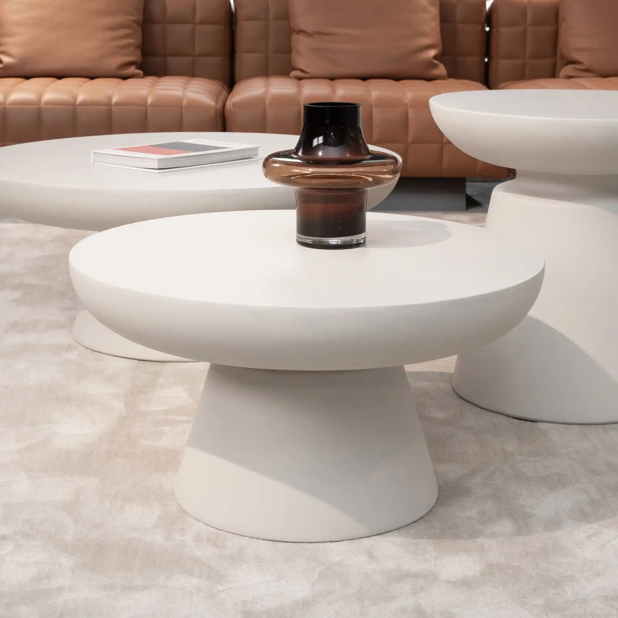 Wohnzimmer mit cremeweißen Wänden und Betonmöbeln