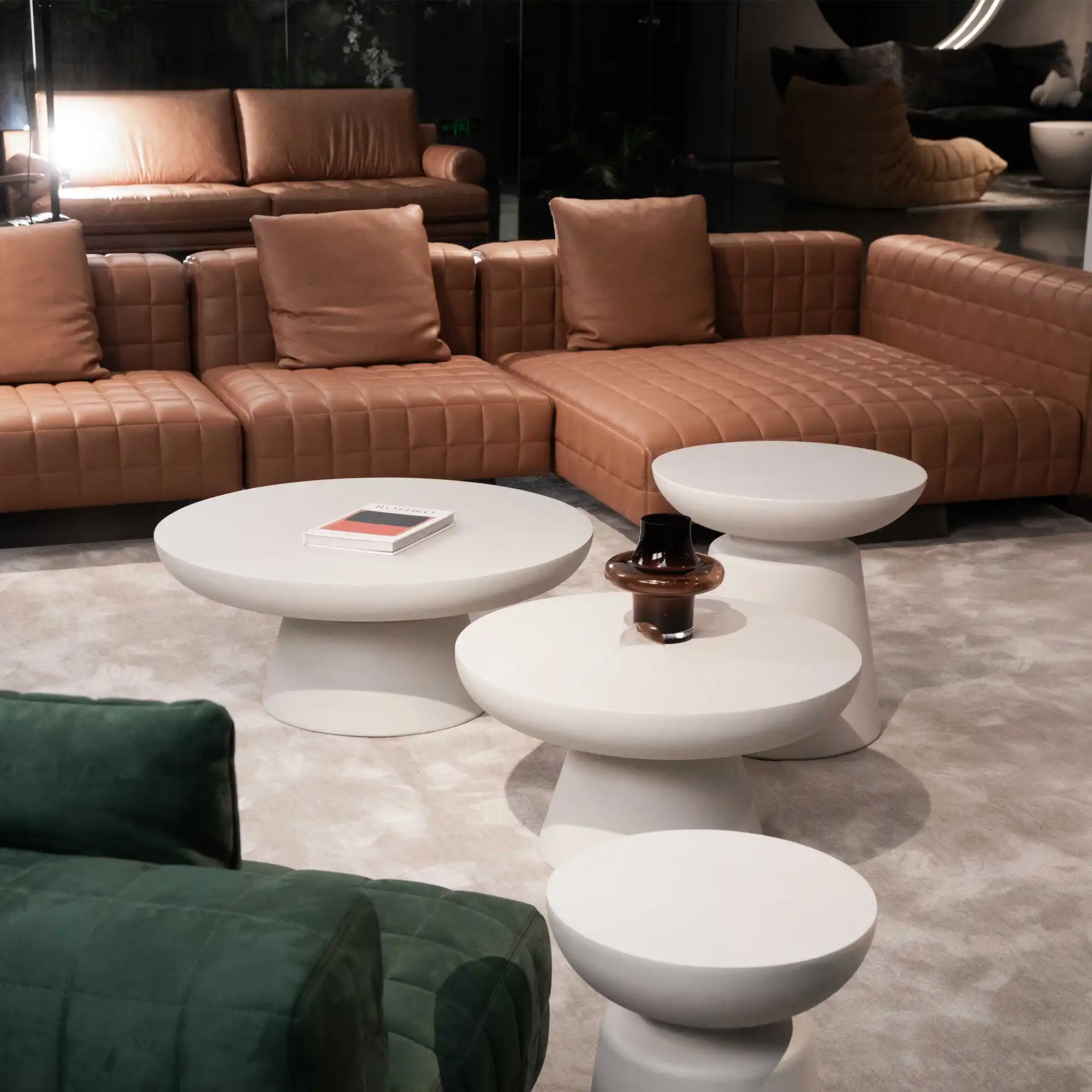 Ronde betonnen salontafel in een kleine woonkamer met een bank