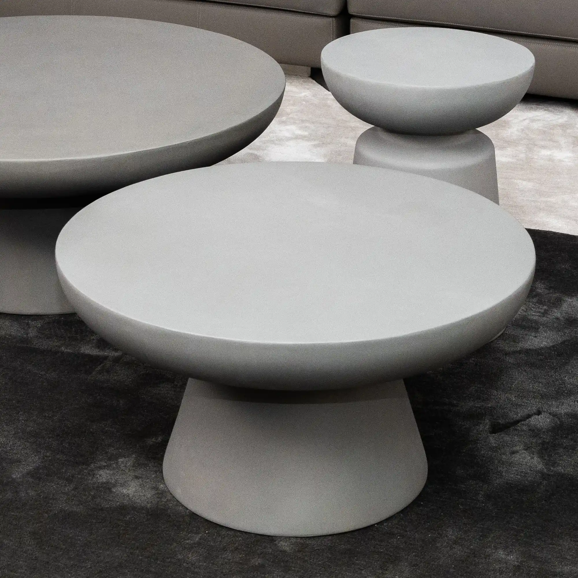 Kleines Wohnzimmer mit Betonmöbeln und Textilien