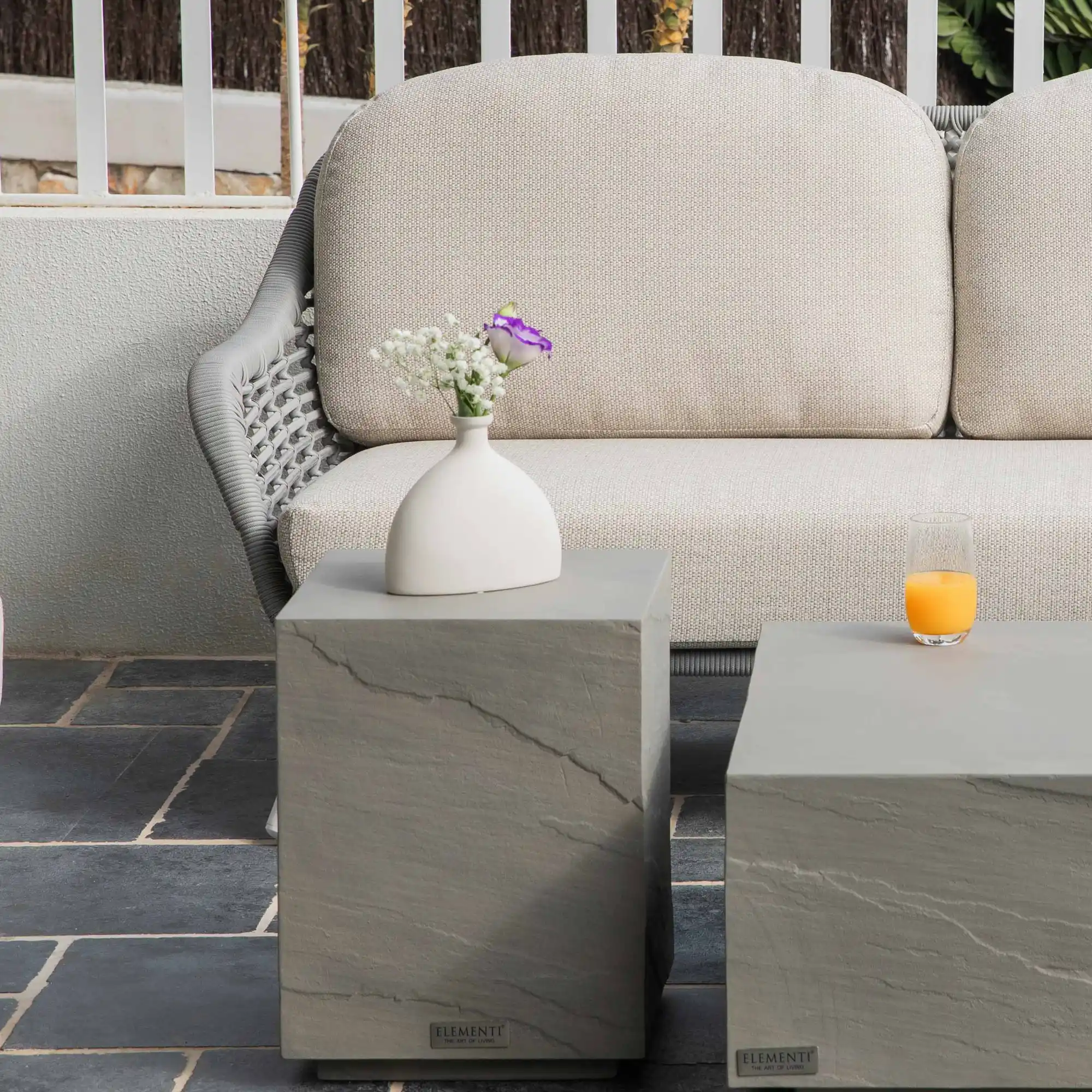 Table d'appoint en béton ajoutée près des assises d'un ensemble de jardin