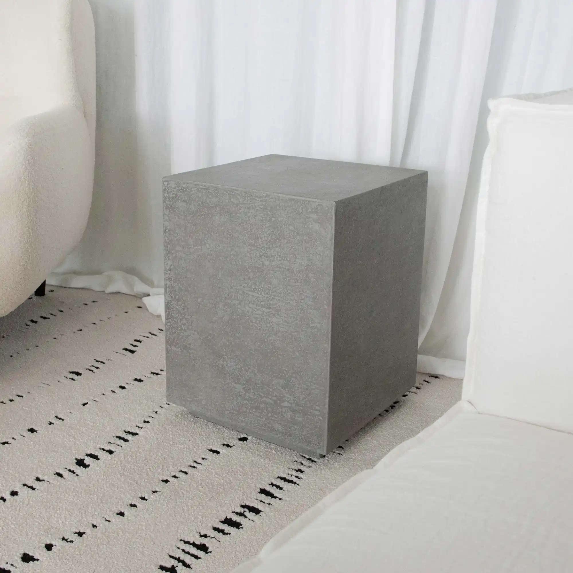 Kleine ronde betonnen bijzettafel in een smalle ruimte