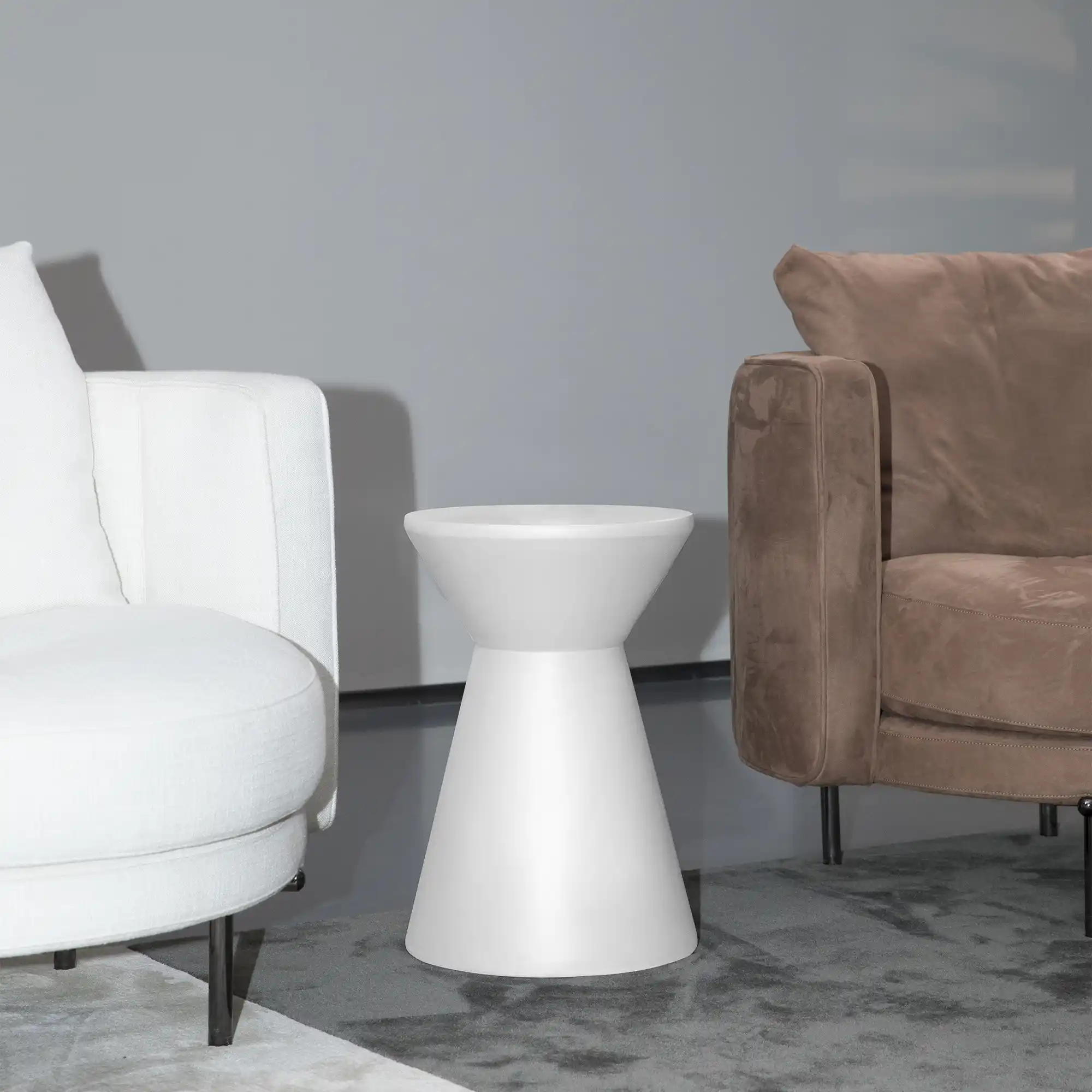 Ronde betonnen salontafel met een hocker erbij