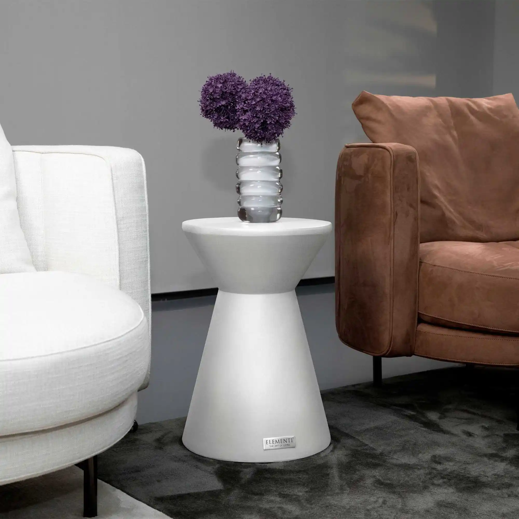 Hocker naast een betonnen salontafel in een kleine woonkamer